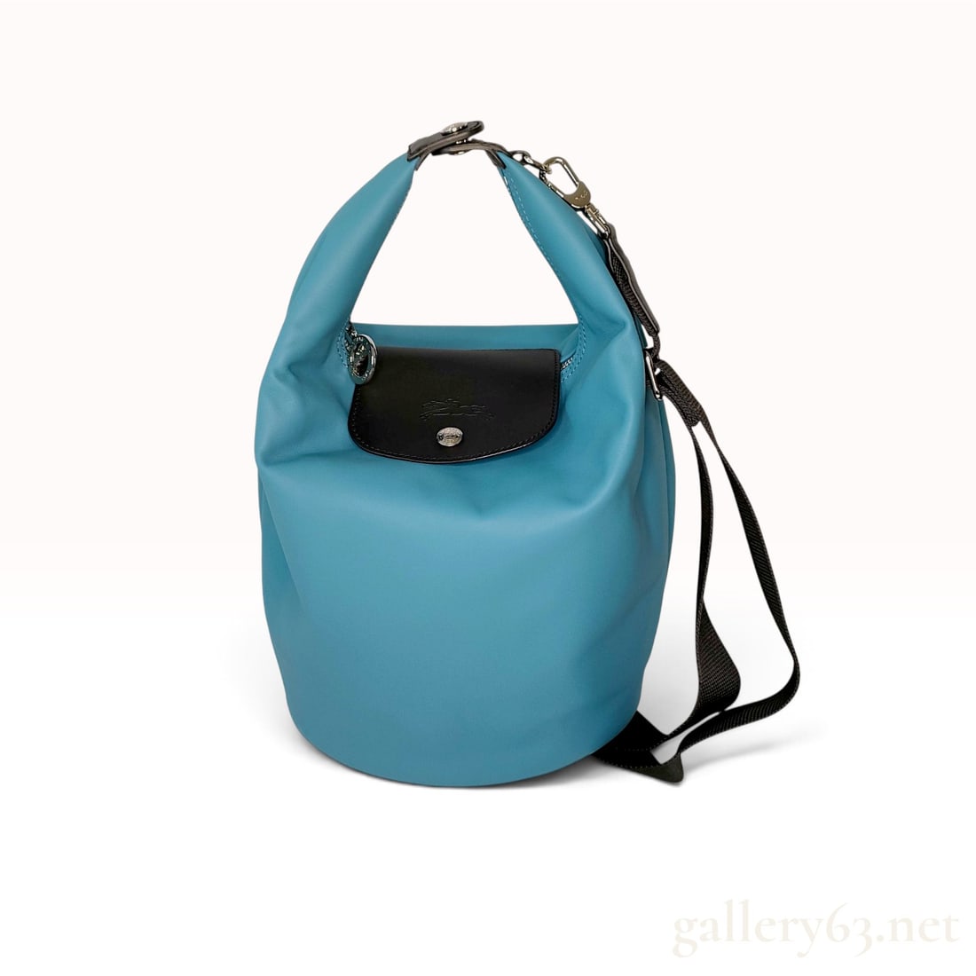 Longchamp Le Pliage Xtra Lagoon Leather Bucket Bag: This Longchamp Le Pliage Xtra bucket bag is crafted from smooth turquoise Metis leather with contrasting black leather trim. The bag features a signature snap-fastened front flap in black leather embo