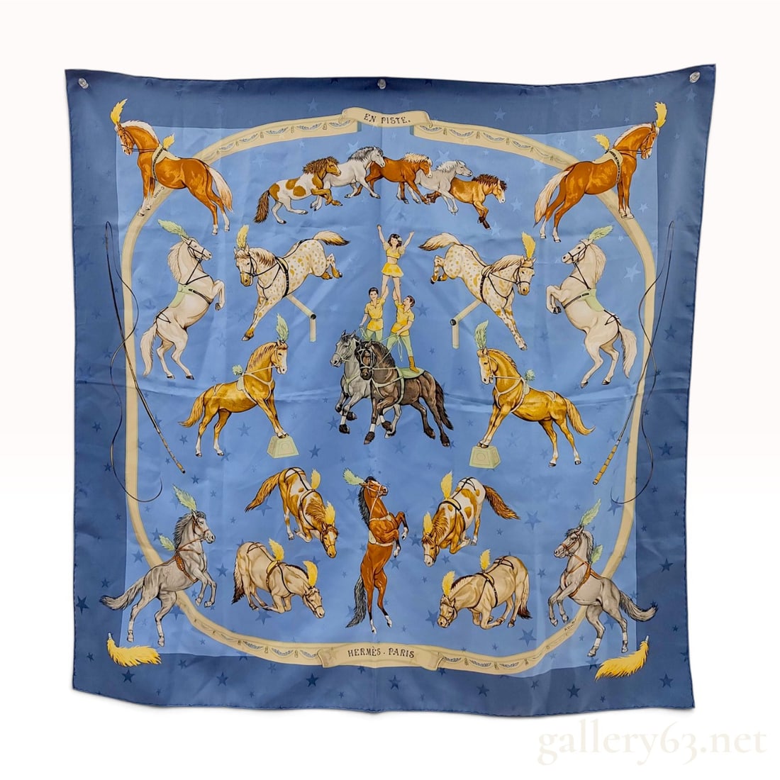 Vintage Hermes En Piste Blue Star Jacquard Silk Carre 90 cm: This Hermes silk carre 90 is crafted from blue 100% silk jacquard fabric in the En Piste (On Track) pattern designed by Robert Dallet. The design depicts circus horses and acrobats performing equestri