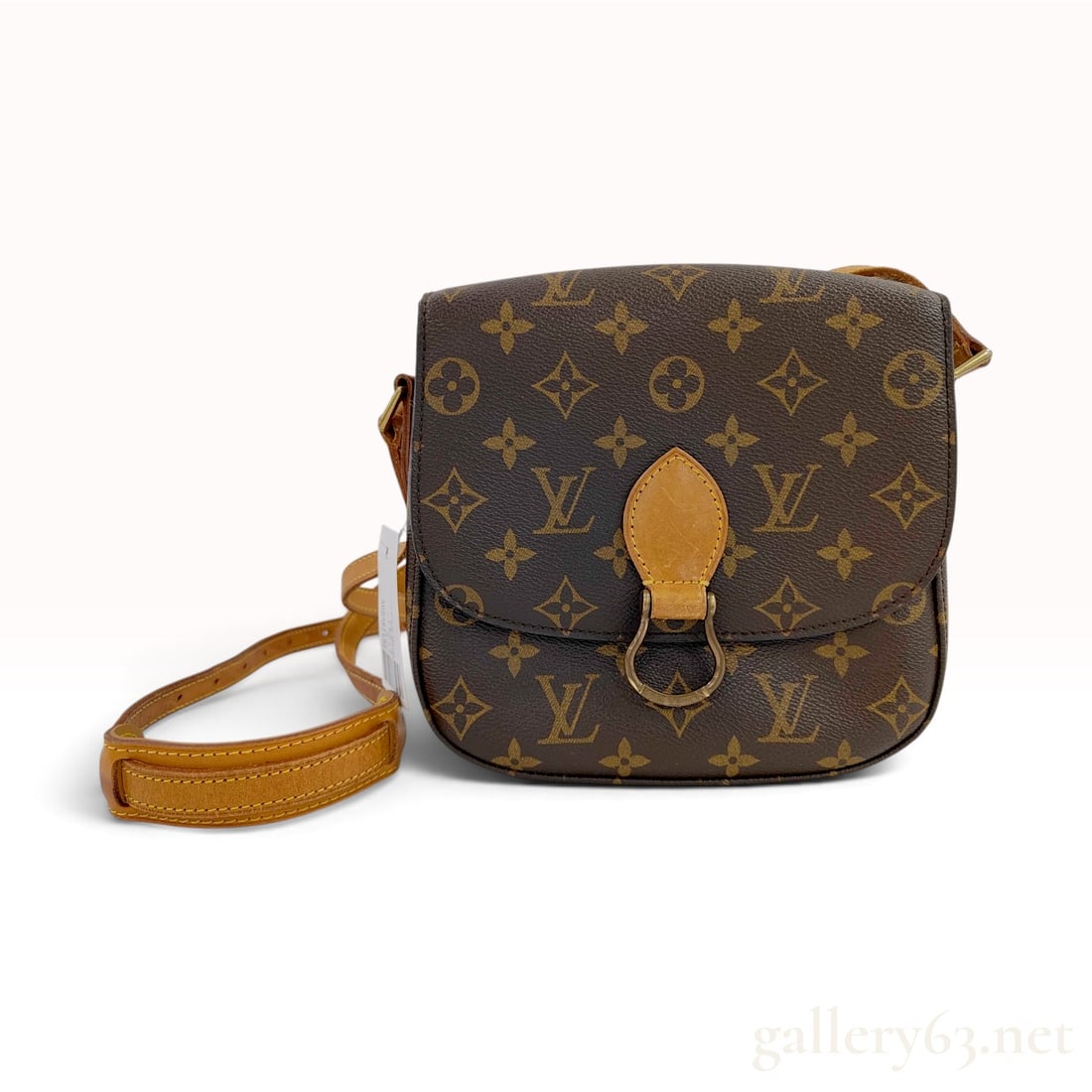 Vintage Louis Vuitton Monogram Saint Cloud PM Brown Coated Canvas Crossbody Bag: This Vintage Louis Vuitton Saint Cloud PM crossbody bag is crafted from the signature brown monogram coated canvas with natural vachetta leather trim. The rounded saddle bag silhouette features a full