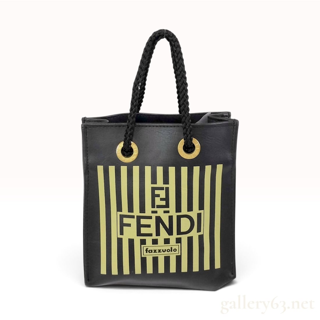 Fendi Fazzuolo Striped Black and Yellow Mini Tote Bag: This Fendi mini tote bag is crafted from black textured material with a black woven fabric interior lining. The front face features a printed yellow vertical stripe pattern. The graphic includes a cen