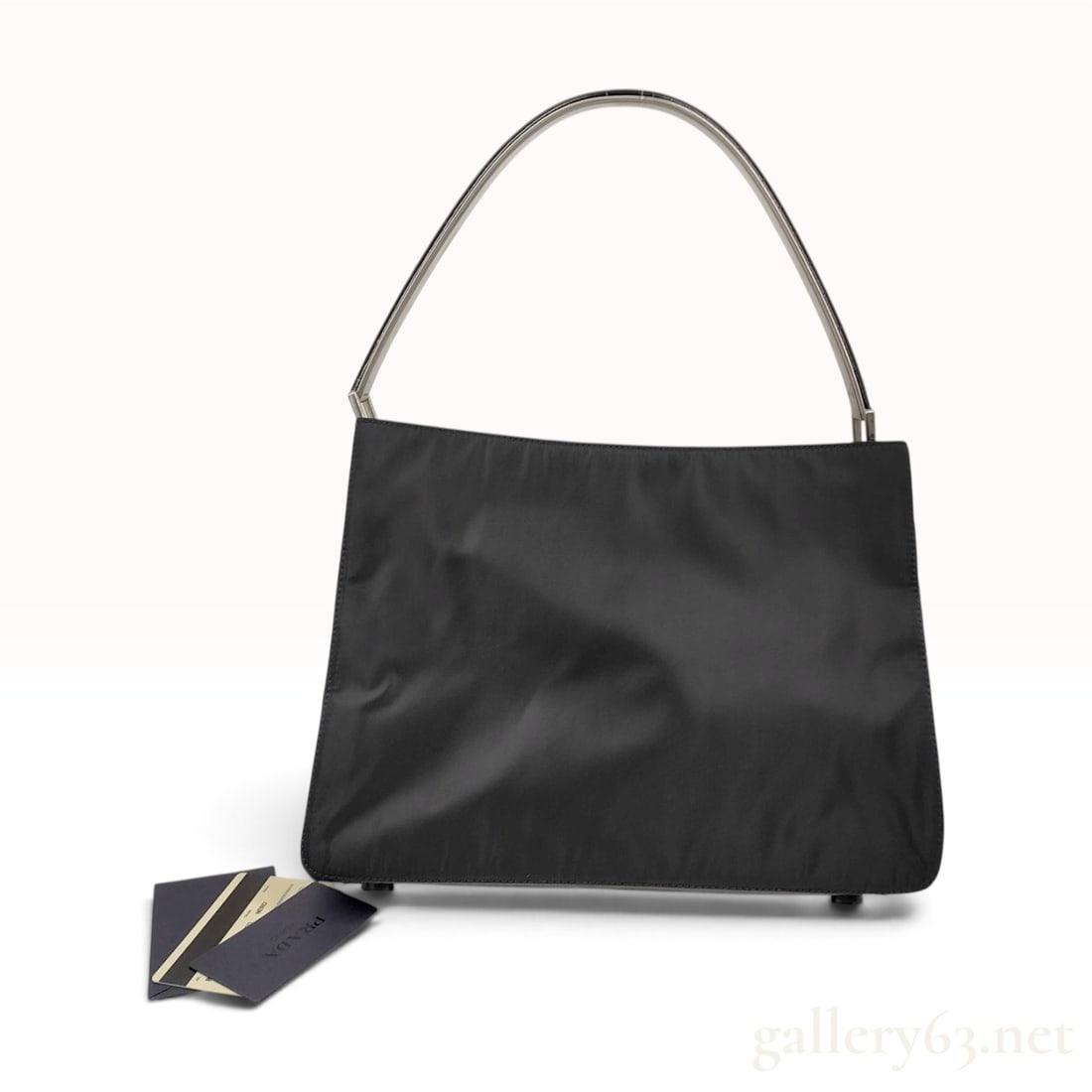 Vintage Prada Cocco Black Nylon and Leather Shoulder Bag with Metal Handle: This Prada shoulder bag is crafted from black tessuto nylon and crocodile-embossed cocco leather. The structured rectangular body is set upon a rigid crocodile-embossed leather base featuring four mat