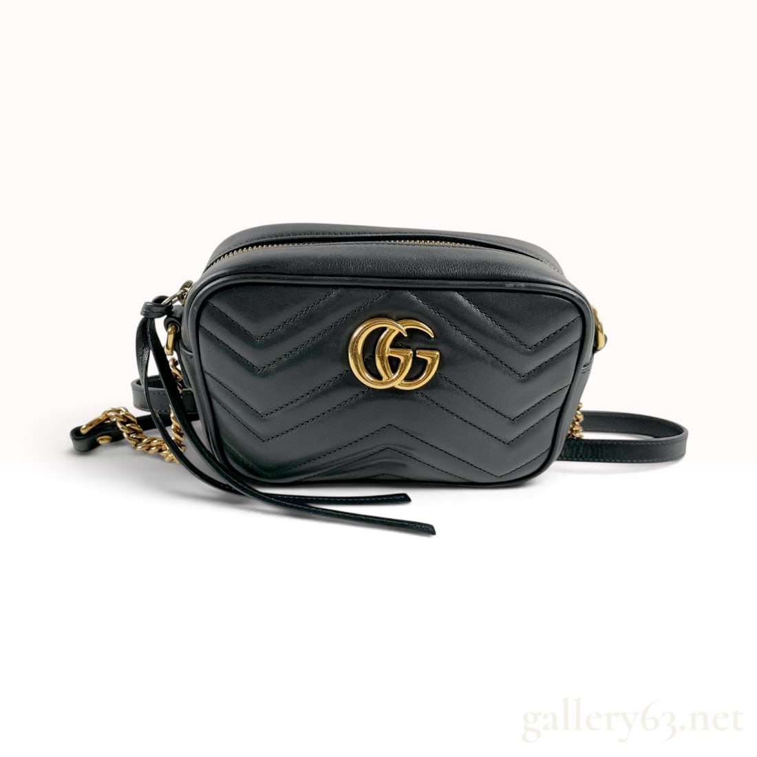 Gucci GG Marmont Small Black Matelasse Leather Shoulder Bag: This Gucci GG Marmont shoulder bag is constructed from black matelasse leather featuring a distinctive chevron-quilted pattern. The rectangular camera-bag silhouette is accented by antiqued gold-toned