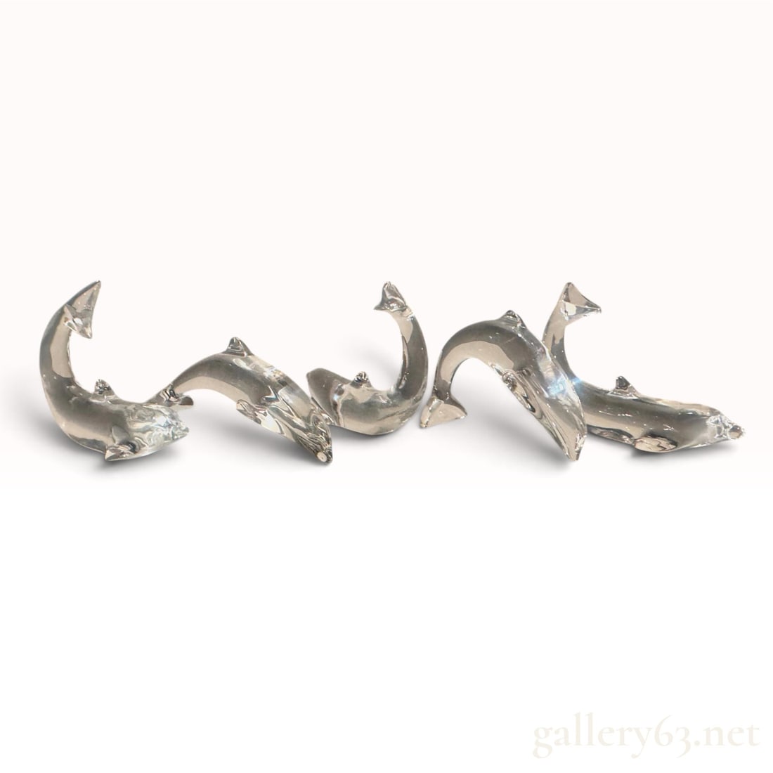 BACCARAT (French) -- Group of Five Clear Crystal Dolphin Sculptures, Signed: Five Baccarat full-lead crystal dolphins, each modeled in a different attitude of movement -- two arched and diving with the tail fluke raised, one rising vertically from a triangular plinth with the