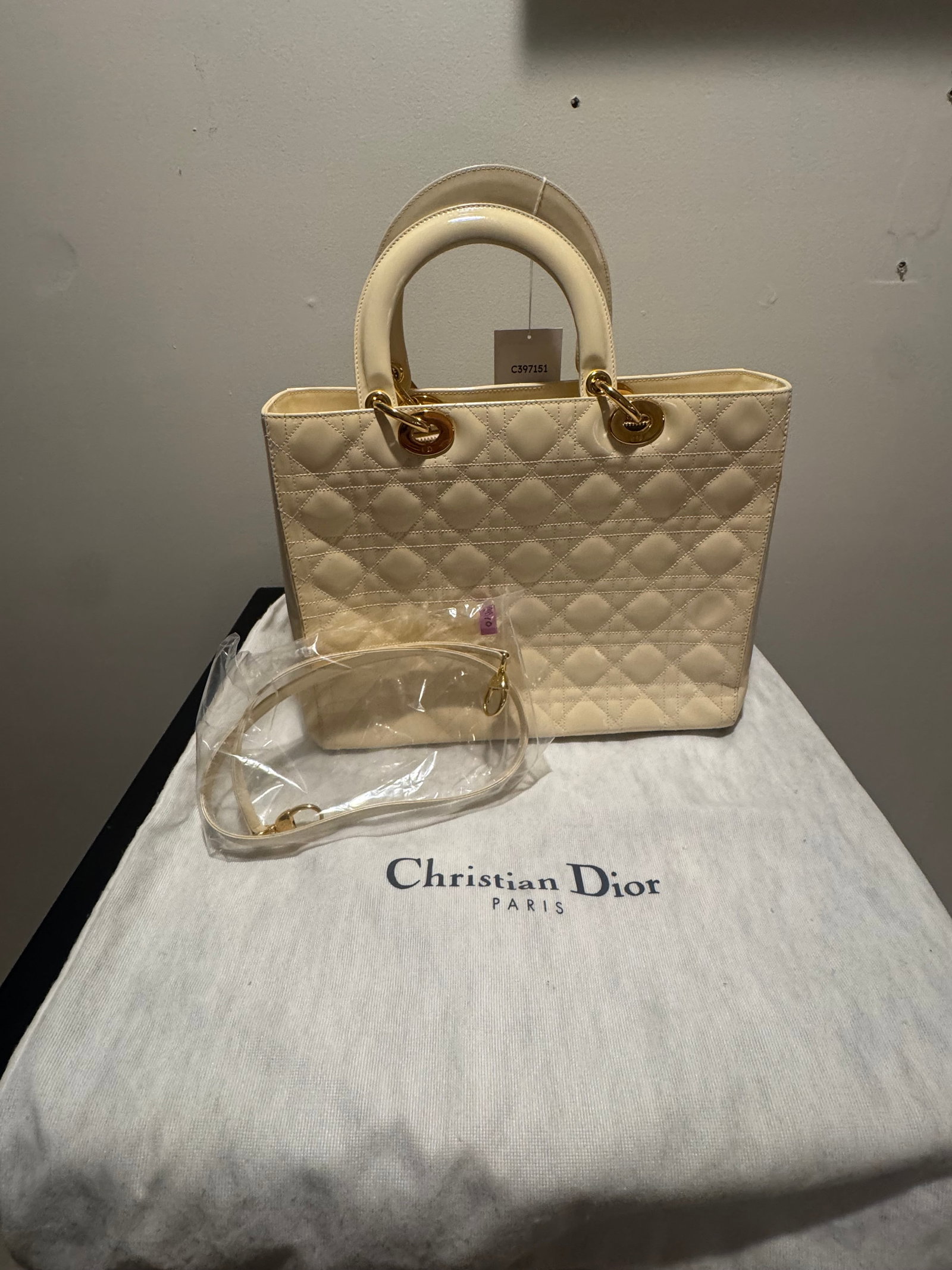 CHRISTIAN DIOR LADY DIOR LARGE, IVORY PATENT CANNAGE, GOLD: Christian Dior Lady Dior in large size, ivory patent leather with the house's Cannage quilting and gold-tone hardware. Padded Cannage panels front and back, twin rolled top handles suspended from over