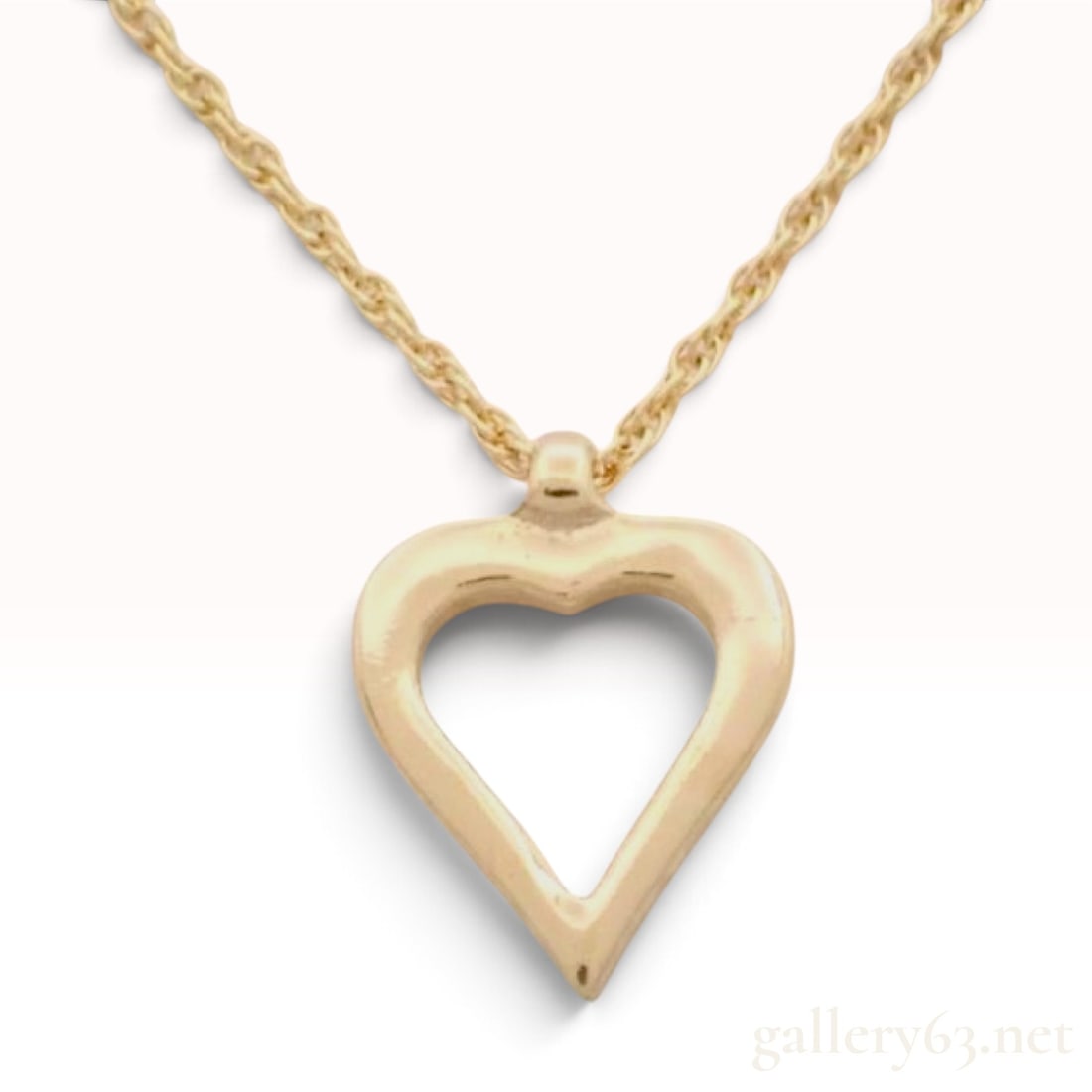 Vintage Christian Dior Open Heart Yellow Gold Toned Necklace: This Christian Dior necklace is crafted from yellow gold-toned metal with a polished finish. The pendant is designed as an open-work heart featuring smooth, rounded contours and an integrated fixed ba