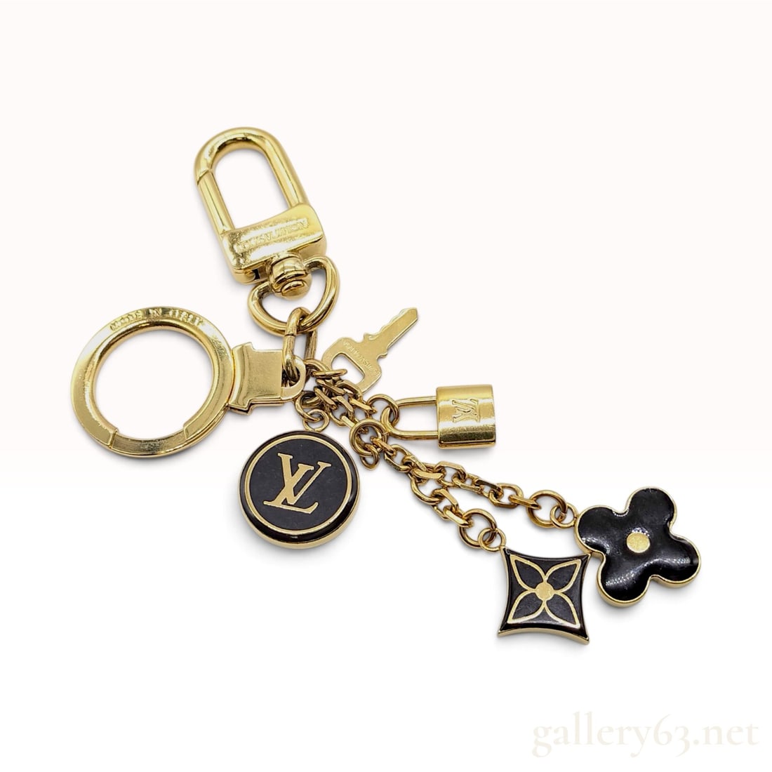 Louis Vuitton Pampille Gold Plated and Enamel Bag Charm: This Louis Vuitton Pampille bag charm is crafted from gold-plated metal and black enamel. The design features a cluster of signature house motifs suspended from link chains, including a circular medal