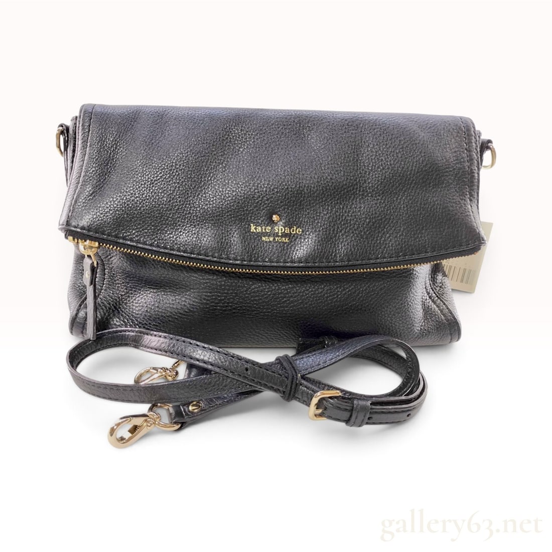 Kate Spade New York Cobble Hill Black Pebbled Leather Foldover Crossbody Bag: This Kate Spade New York crossbody bag is crafted from black pebbled leather featuring a fold-over design. The construction includes a top zipper closure integrated into the flap and an adjustable, re