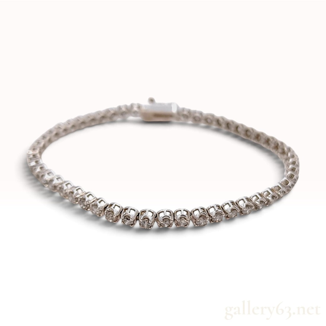 18KWG 3.00ctw Natural Diamond Tennis Bracelet: This tennis bracelet is crafted from 18 karat white gold and features a continuous strand of round brilliant-cut natural diamonds held in articulated four-prong basket settings. The diamonds have a to