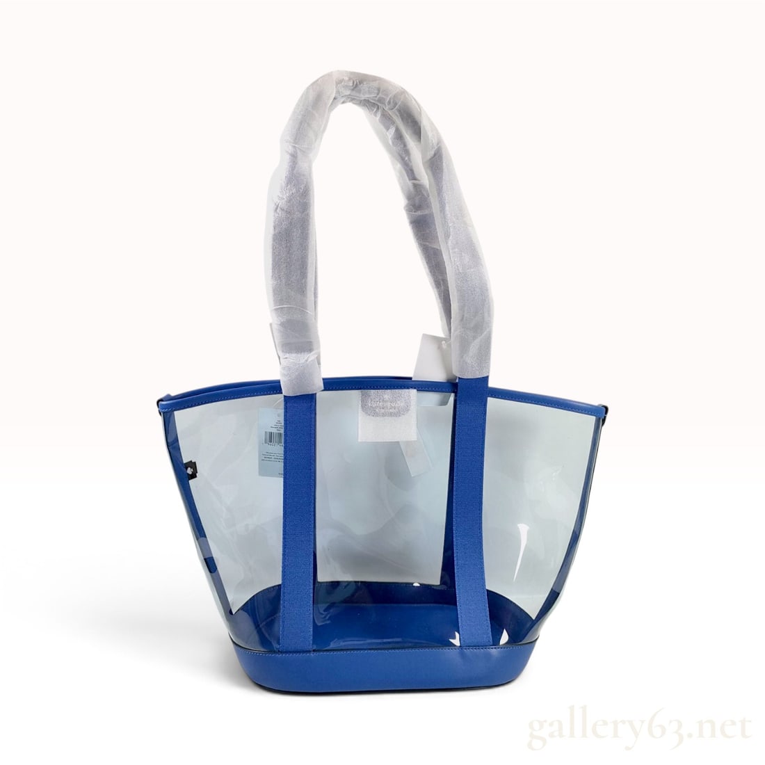 NWT Kate Spade New York Cobalt Blue Transparent PVC Tote Bag: This Kate Spade New York tote bag is crafted from transparent blue-tinted PVC with a cobalt blue pebbled leather base and matching top trim. The bag features an open-top design with dual shoulder stra