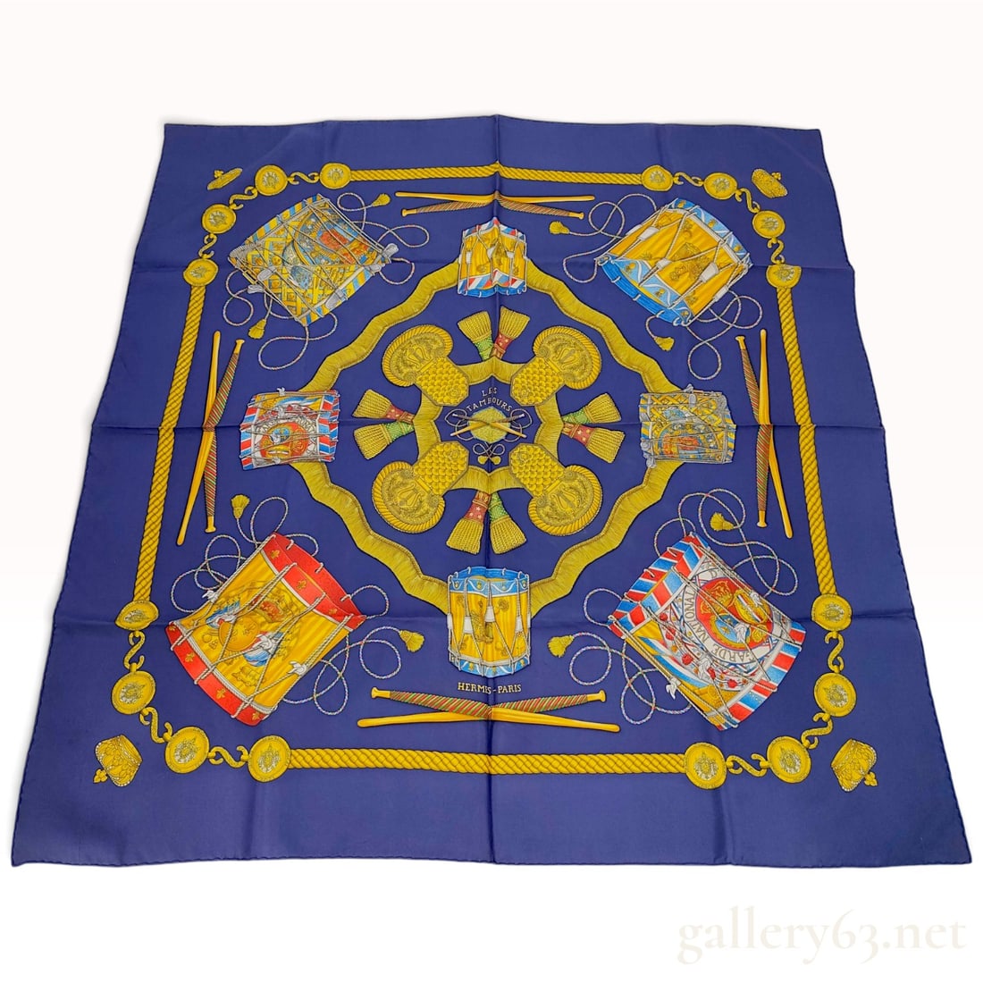 Vintage Hermes Les Tambours Silk Carre 90: This Hermes silk carre 90 features the Les Tambours pattern designed by Joachim Metz. The design centers on four military epaulettes with lyre emblems, surrounded by various 18th and 19th-century mili