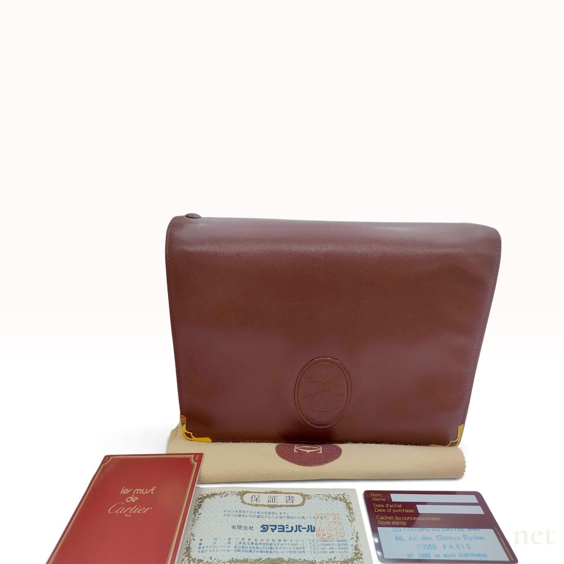 Vintage Cartier Must Line Burgundy Calfskin Clutch Bag with Accessories: This Cartier Must de Cartier clutch bag is crafted from smooth burgundy calfskin leather. The rectangular design features a front flap closure with an embossed interlocking C logo set within an oval f