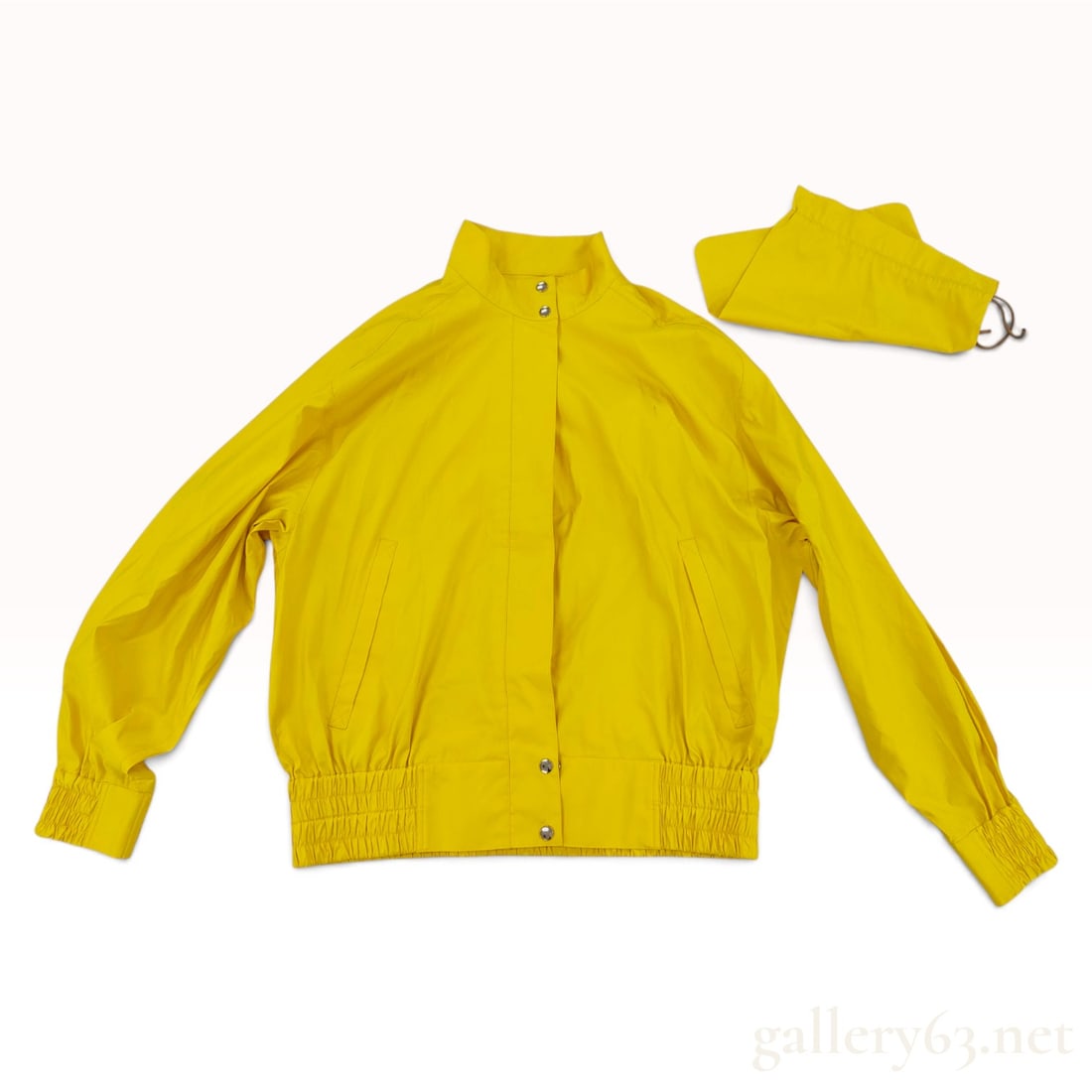 Vintage Christian Dior Sports Yellow Windbreaker Jacket Size M with Pouch: This vintage Christian Dior Sports jacket is a lightweight windbreaker crafted from a yellow polyester and nylon blend fabric. The garment features a stand collar with two snap-button closures and a f