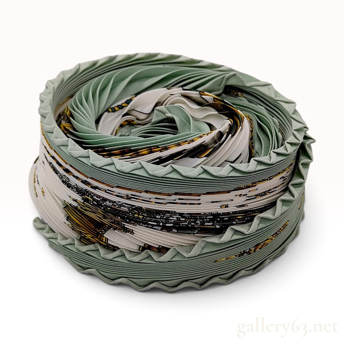 Hermes Les Tambours Sage Green Silk Plisse Scarf with Box: This Hermes silk plisse scarf is crafted from 100% silk and features the Les Tambours pattern designed by Joachim Metz. The design centers on military percussion instruments, notably a large drum labe