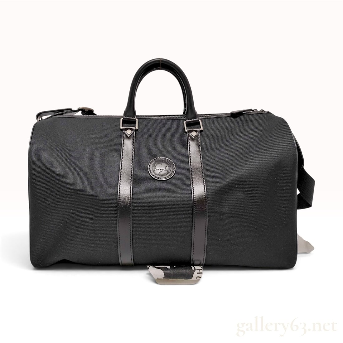 Hunting World Black Canvas and Leather Travel Boston Bag with Shoulder Strap: This Hunting World travel Boston bag is constructed from black canvas featuring a prominent diagonal twill weave, accented by smooth black leather trim. The exterior design includes two vertical leath