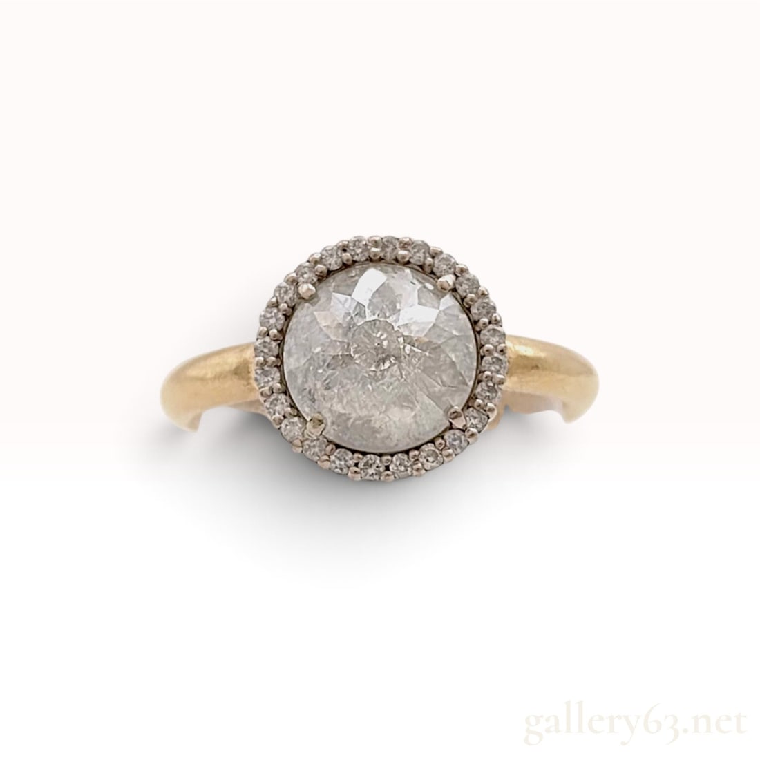 18KYG Rose Cut Diamond Halo Ring: This is a contemporary halo ring centered with a round rose-cut natural diamond. The center stone displays a translucent grey color with characteristic salt and pepper inclusions and is secured in a w