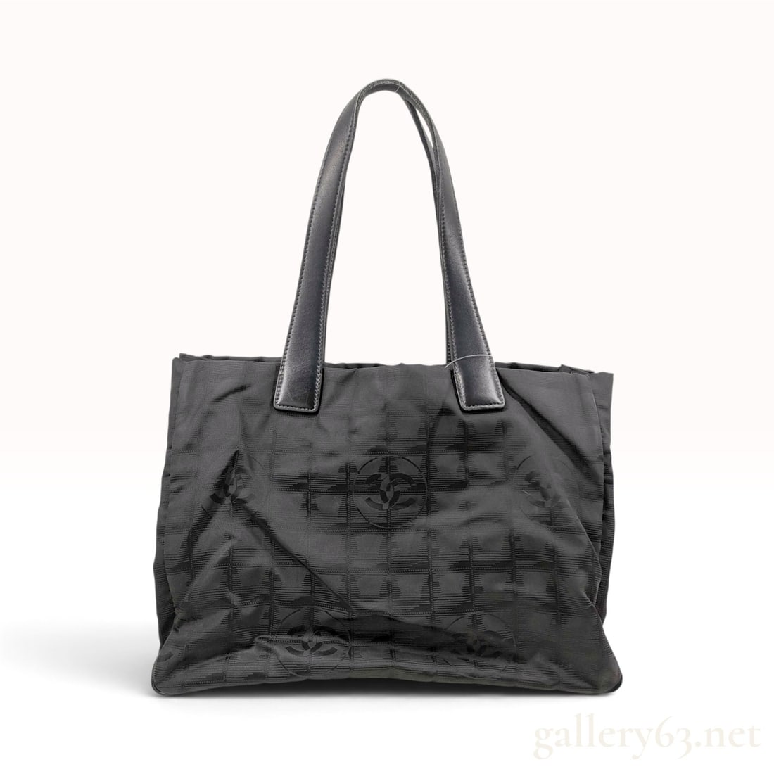 Vintage Chanel New Travel Line Black Jacquard Tote Bag MM: This Chanel New Travel Line tote bag is crafted from black jacquard nylon featuring a tonal square grid pattern interwoven with signature interlocking CC logos. The bag features two flat leather shoul