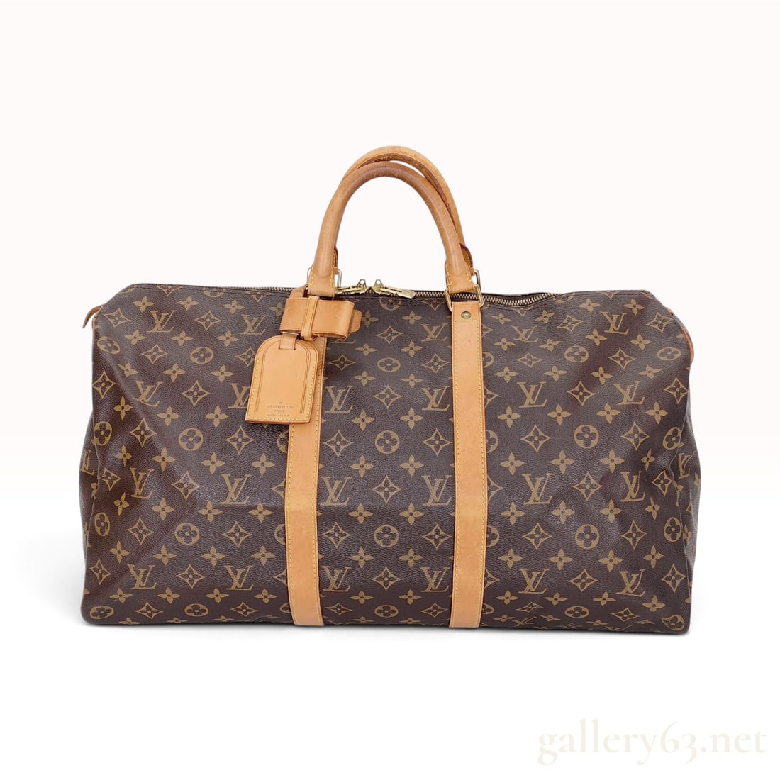 Vintage Louis Vuitton Monogram Keepall 55 Canvas Travel Bag: This Louis Vuitton Keepall 55 travel bag is crafted from the signature brown monogram coated canvas with honey-toned patinated Vachetta leather trim and dual rolled top handles. The duffle-style duffe