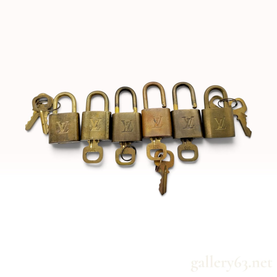 Vintage Louis Vuitton Brass Padlocks and Keys: This collection of six Louis Vuitton padlocks is crafted from brass for use with luxury travel luggage and handbags. Each rectangular padlock features the relief-stamped LV monogram on the front face.