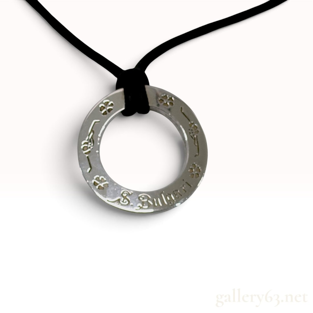 Bvlgari Save the Children Sterling Silver Ring Pendant Necklace: This Bvlgari pendant necklace is crafted from sterling silver as part of the Save the Children collection. The piece features a circular, flat ring-style pendant suspended from a black woven cord. The