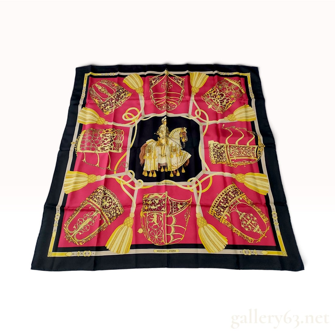 Vintage Hermes Les Muserolles Red and Black Silk Carre 90: This Hermes silk carre 90 is crafted from silk twill in the Les Muserolles pattern designed by Christiane Vauzelles. The design centers on a black medallion featuring an armored knight on a caparisone