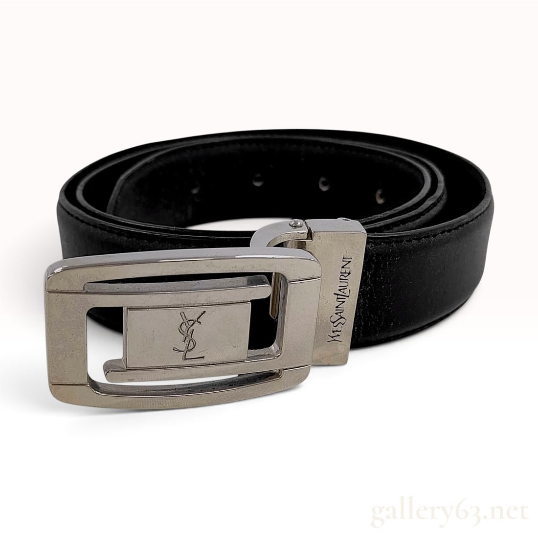 Vintage Yves Saint Laurent Black Leather Belt: This Yves Saint Laurent belt is crafted from black leather and features silver-tone metal hardware. The rectangular frame buckle includes a central rectangular plate embossed with an intertwined YSL m