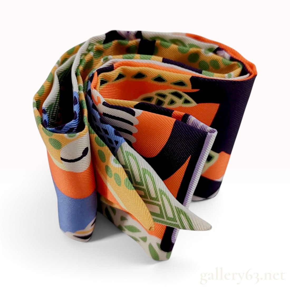 Hermes Orange and Navy Equestrian Motif Silk Twilly Scarf: This Hermes Twilly scarf is crafted from 100% silk twill featuring an abstract equestrian design with braided cords, circular links, and geometric patterns. The vibrant colorway includes orange, navy 