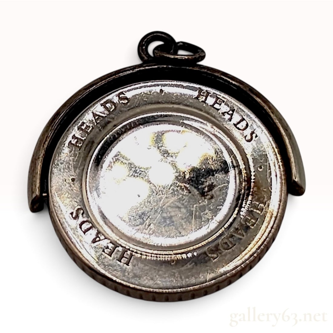 Tiffany & Co. Heads Tails Sterling Silver Spinning Swivel Pendant: This Tiffany & Co. spinning swivel pendant is crafted from sterling silver. The design features a central rotating disc suspended within a U-shaped swivel frame, allowing the center to spin freely. Th