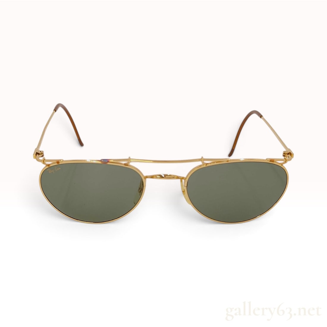 Vintage Ray-Ban Deco Metals Oval Gold-Toned Sunglasses with Case: These vintage Ray-Ban sunglasses from the Bausch & Lomb era feature the Deco Metals oval frame design. The gold-toned metal wire frames are characterized by fine textured engraving along the top brow 