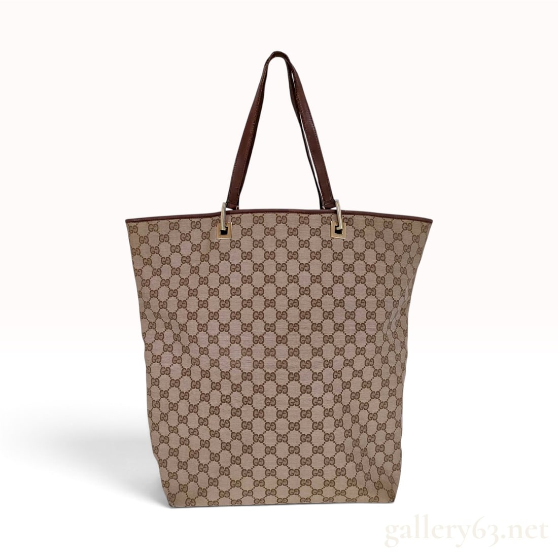 A Vintage Gucci GG Monogram Canvas and Brown Leather Tote Bag: This Gucci tote bag is crafted from signature GG monogram canvas with dark brown leather trim, base, and handles. The large rectangular body features a beige and ebony canvas exterior with the house r