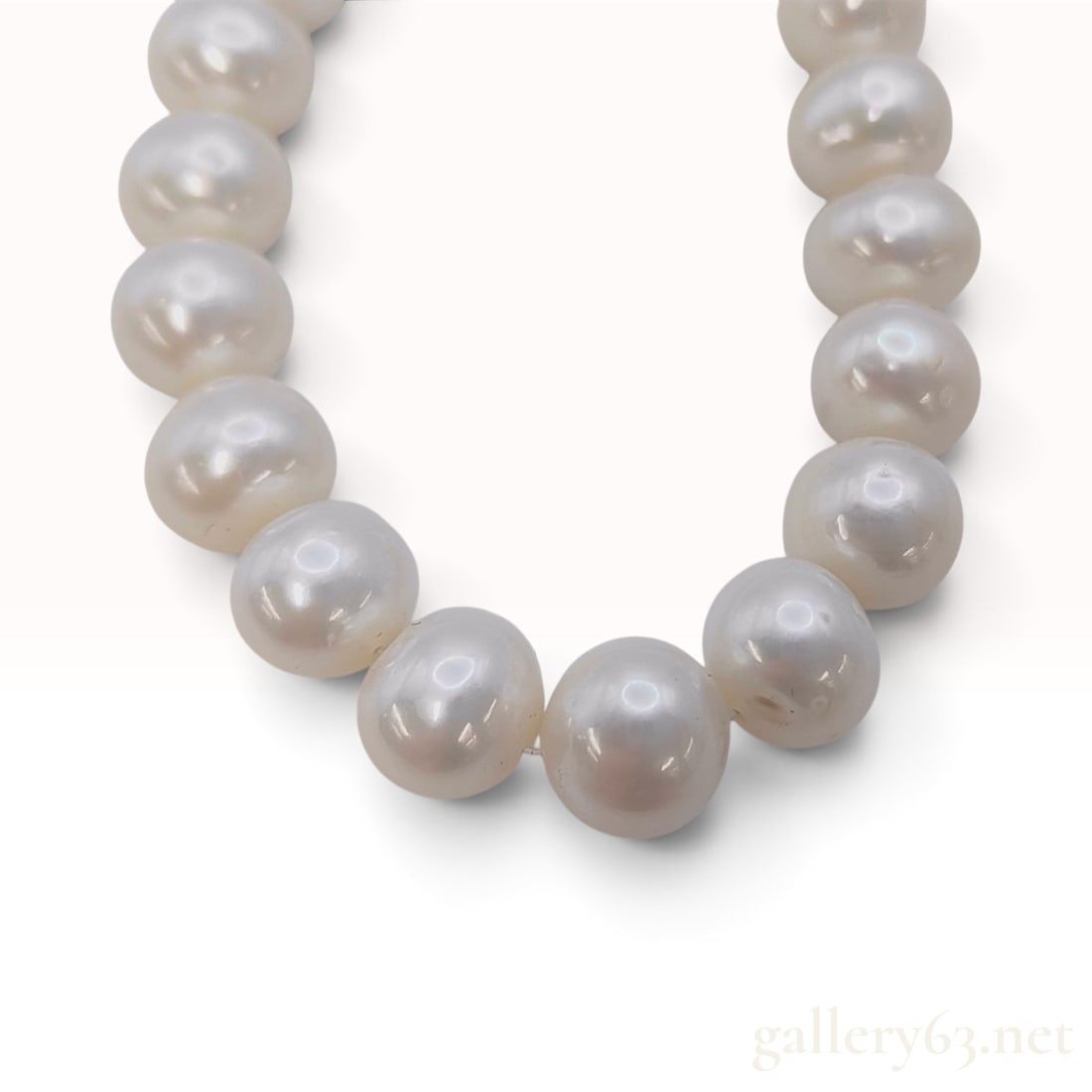 A Single Strand Cultured Pearl Necklace with Yellow Gold Toned Clasp: This single-strand cultured pearl necklace is composed of forty-three pearls. The pearls are near-round to semi-round in shape and feature a white body color with creamy overtones. Surface characteris