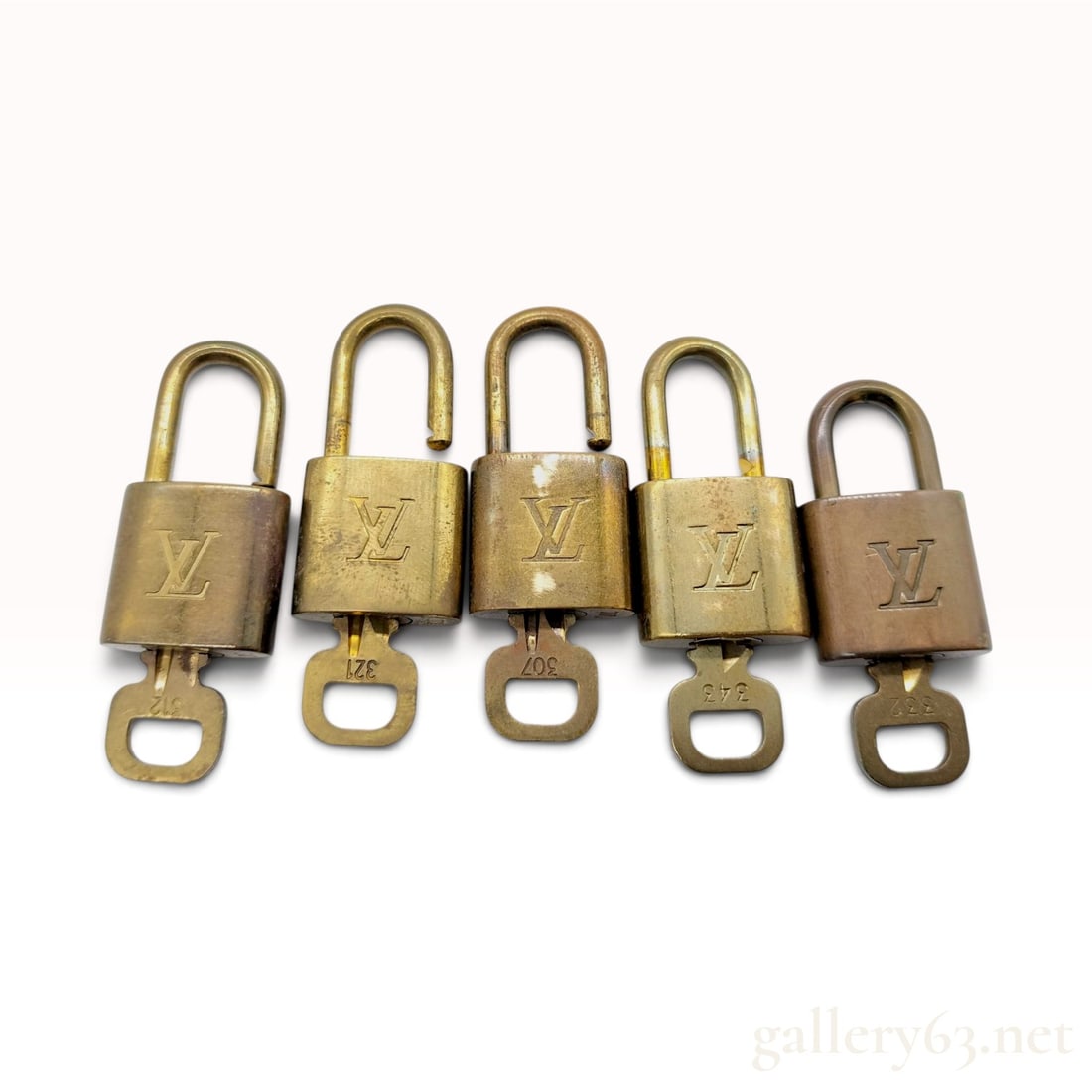Vintage Louis Vuitton Monogram Brass Padlock and Key Set of Five: This Louis Vuitton padlock and key set is crafted from solid brass with a natural aged finish. The group consists of five individual padlocks, each accompanied by its original matching key. The front 