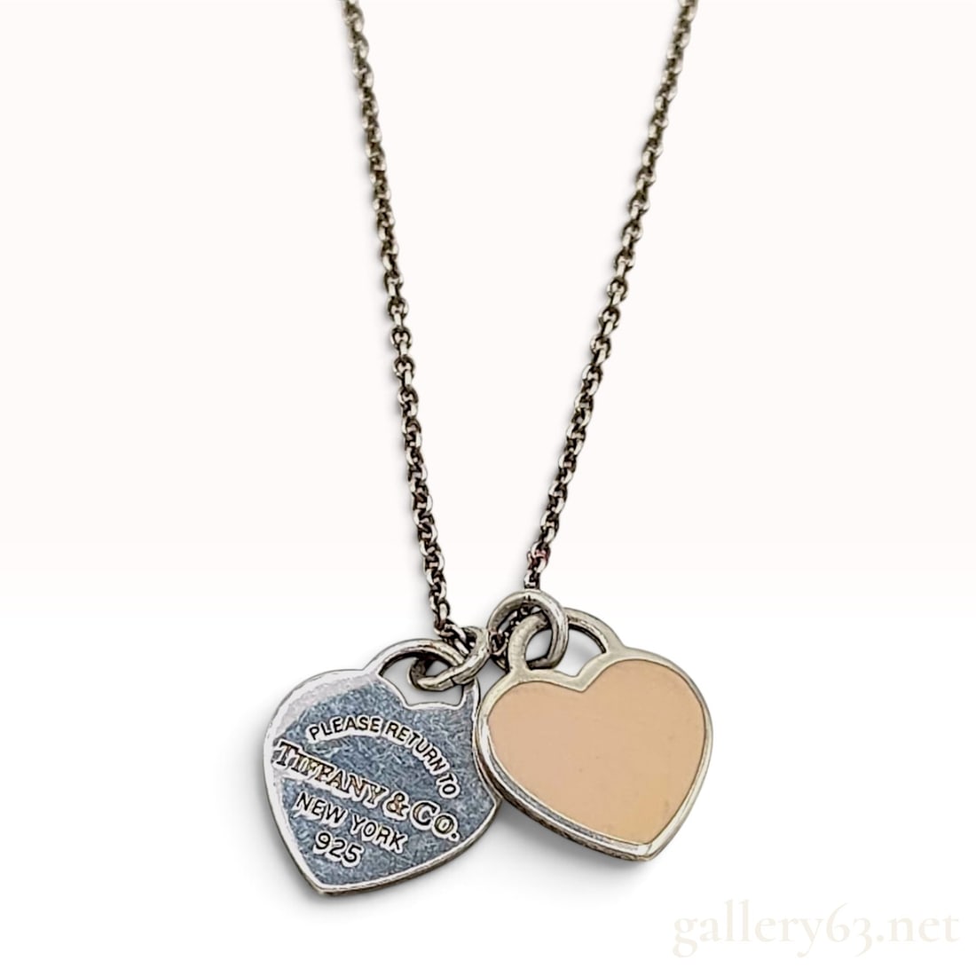 Tiffany & Co. Return to Tiffany Sterling Silver and Pink Enamel Double Heart Tag Pendant Necklace: This Tiffany & Co. pendant necklace is crafted from sterling silver and features the brand's signature double heart tag motif. The design comprises two heart-shaped charms suspended from a delicate ca