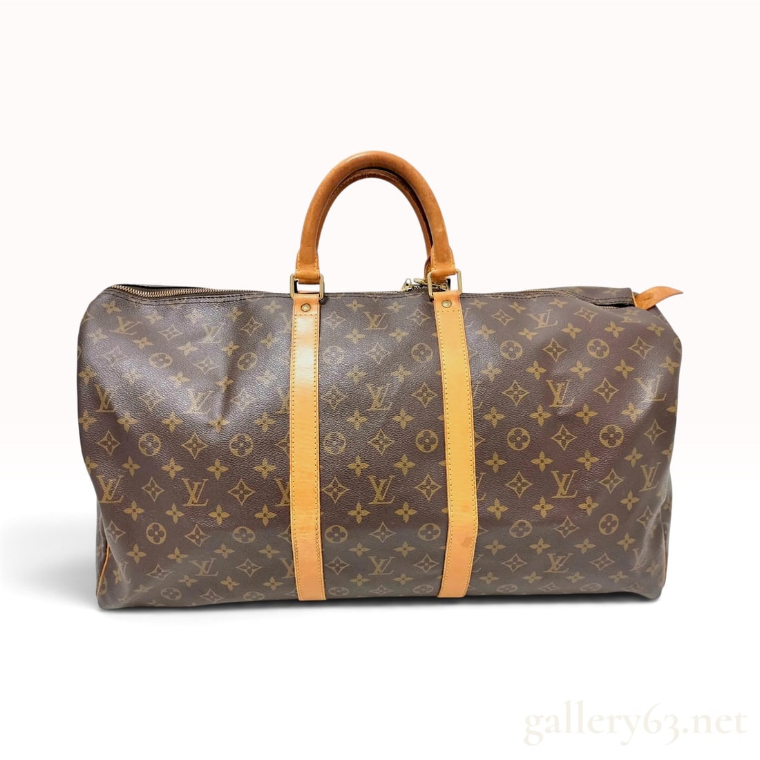 Vintage Louis Vuitton Keepall 60 Monogram Canvas Travel Bag: This Louis Vuitton Keepall 60 travel bag is crafted from signature monogram coated canvas with natural vachetta leather trim and handles. The classic Boston-style silhouette features double rolled lea