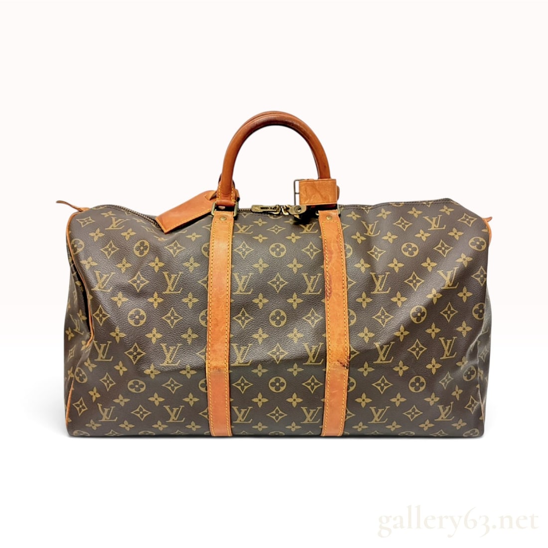 Vintage Louis Vuitton Monogram Canvas Keepall 50 Travel Bag with Padlock: This Louis Vuitton Keepall 50 travel bag is crafted from signature monogram coated canvas with natural vachetta leather trim. The exterior features the repeating LV monogram logo interspersed with flo