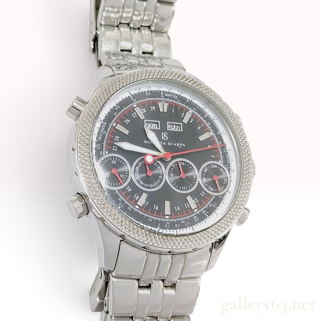 Roberta Scarpa Multi-function Black Dial Stainless Steel Automatic Watch 43mm: This Roberta Scarpa multi-function automatic wristwatch is constructed with a stainless steel case and a matching multi-link bracelet. The black dial features silver-toned hour markers and red-tipped 