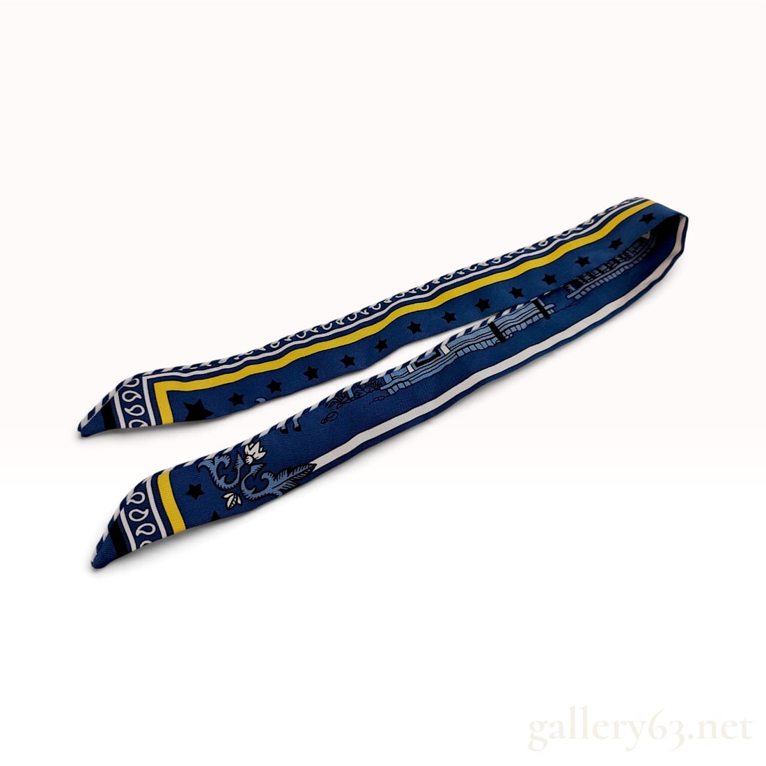 Hermes Pani La Shar Pawnee Blue Silk Twilly Scarf with Box: This Hermes silk twilly scarf is printed with the Pani La Shar Pawnee pattern, featuring a complex arrangement of equestrian and celestial motifs on a navy blue ground. The decorative design includes 