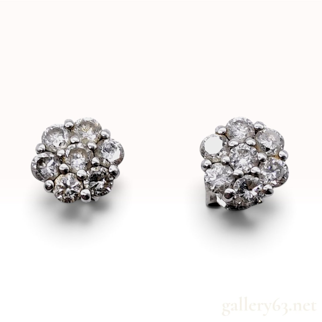 Pt900 and 0.60ctw Natural Diamond Floral Cluster Stud Earrings: This is a matched pair of floral cluster stud earrings crafted from Pt900. Each earring head is designed as a circular flower motif, set with a central natural diamond surrounded by a halo of six roun