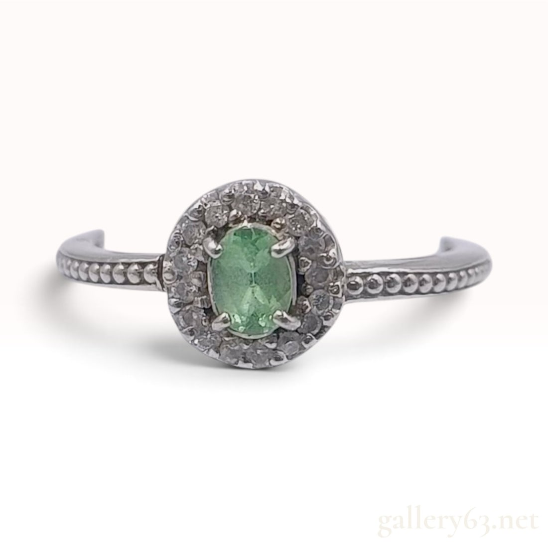 0.19ct Natural Tsavorite and 0.08ctw Natural Diamond Pt900 Ring With NGL Report: This Pt900 platinum ring features a central 0.19ct natural green grossular garnet, identified as tsavorite. The oval mixed-cut gemstone is held in a four-prong setting and surrounded by a halo of roun