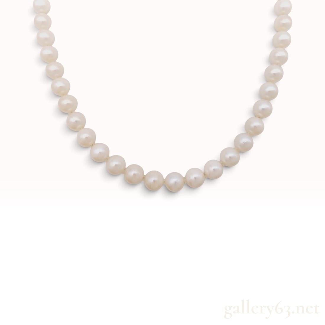 Sterling Silver and White Cultured Pearl Single Strand Necklace 40 cm: This single strand necklace is composed of cultured pearls individually knotted on a white cord. The pearls exhibit a cream to white color with soft pink overtones and a satiny luster. The strand is f
