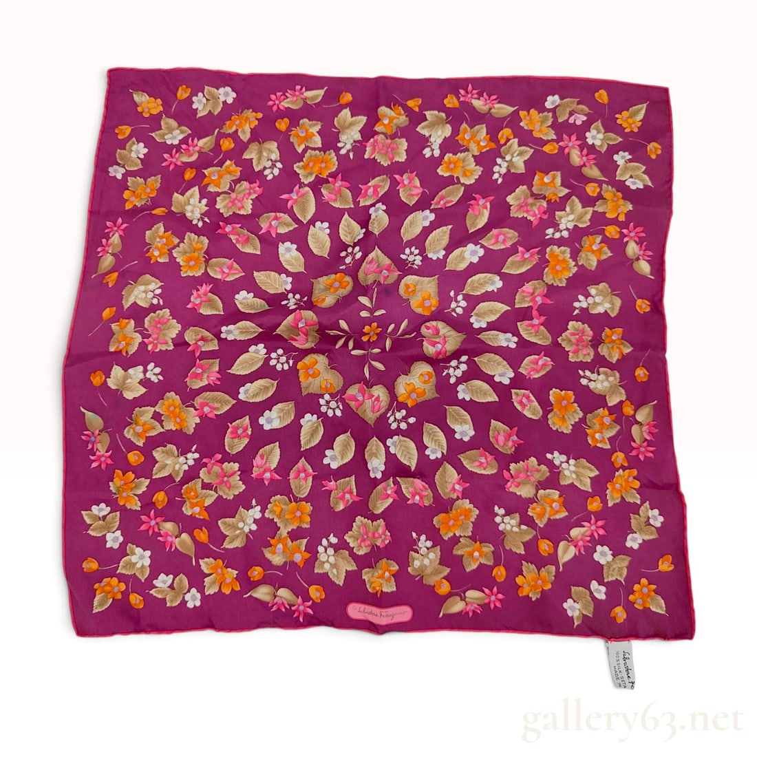 Salvatore Ferragamo Magenta Floral Silk Carre 45: This Salvatore Ferragamo silk carre 45 is crafted from 100 percent silk twill. The design features a vibrant floral and foliate pattern set against a magenta ground, showcasing orange blossoms, pink f