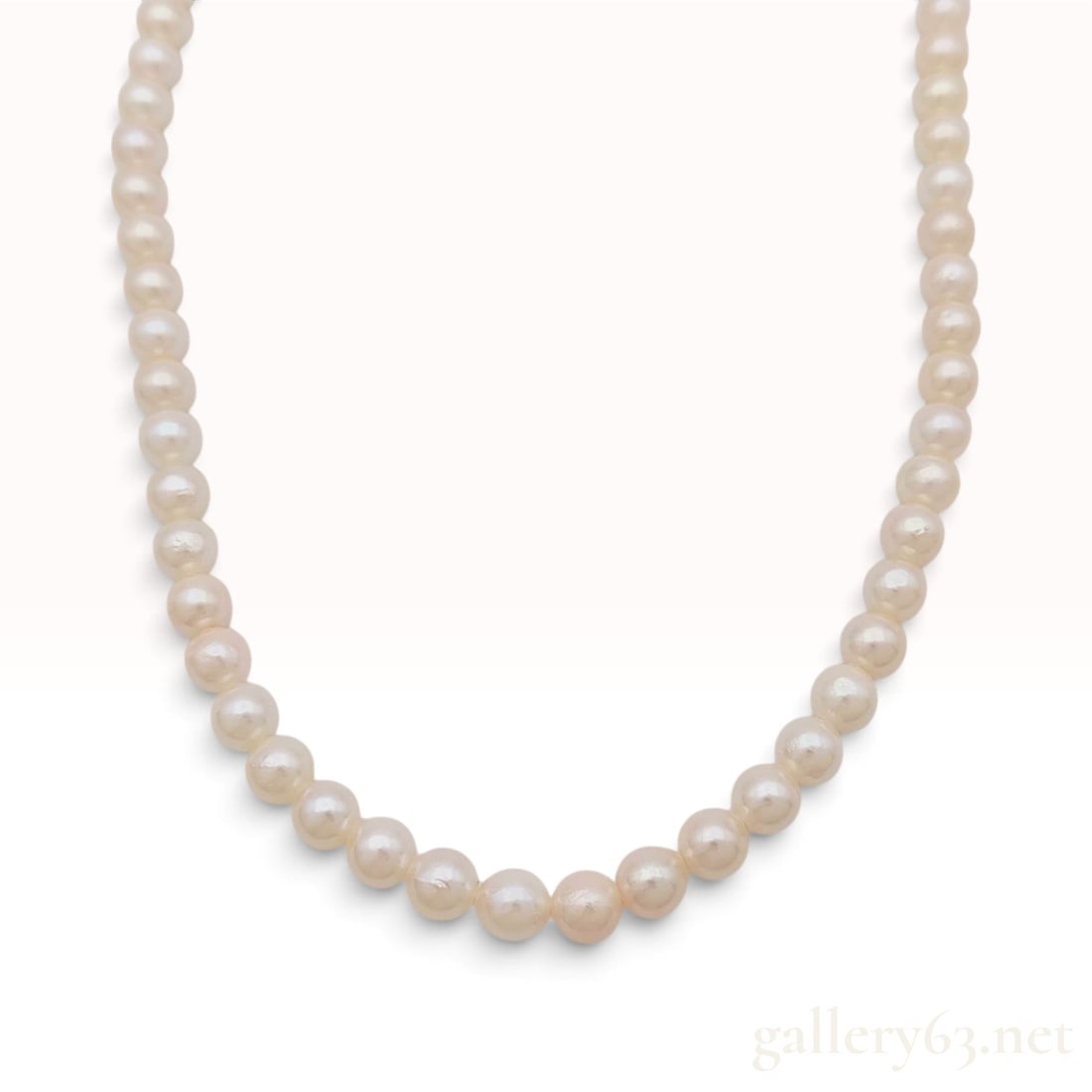 Vintage Silver and Cream Cultured Pearl Necklace 16.5 Inch: This silver and cultured pearl necklace consists of a single strand of approximately 70 near-round pearls measuring between 5.5mm and 6mm in diameter. The pearls exhibit a creamy white body color with
