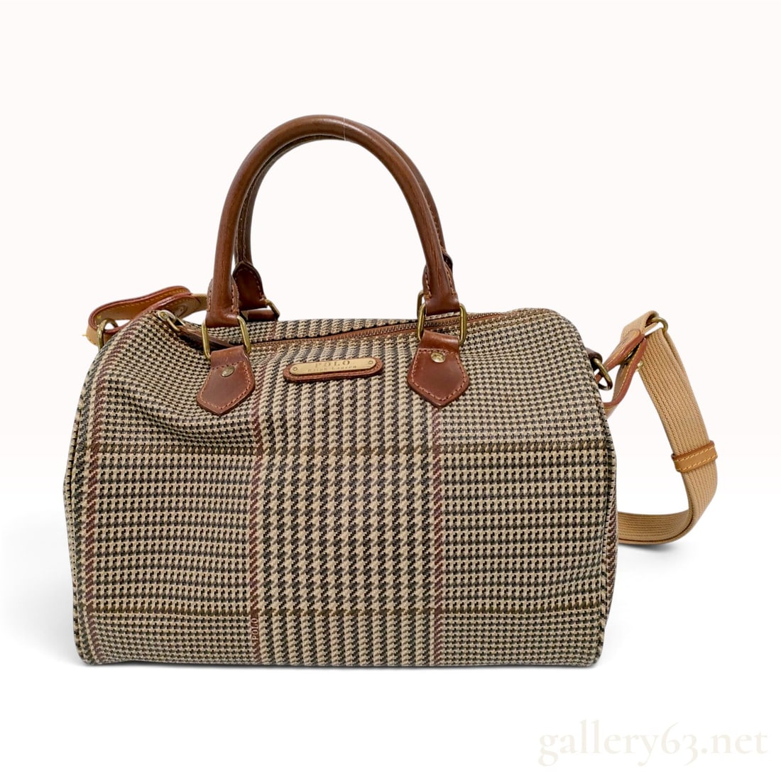 Vintage Polo Ralph Lauren Glen Plaid Coated Canvas Boston Satchel Bag: This vintage Polo Ralph Lauren Boston satchel bag is constructed from coated canvas featuring a brown and tan Prince of Wales check pattern with a red overcheck. The bag is trimmed with brown leather,