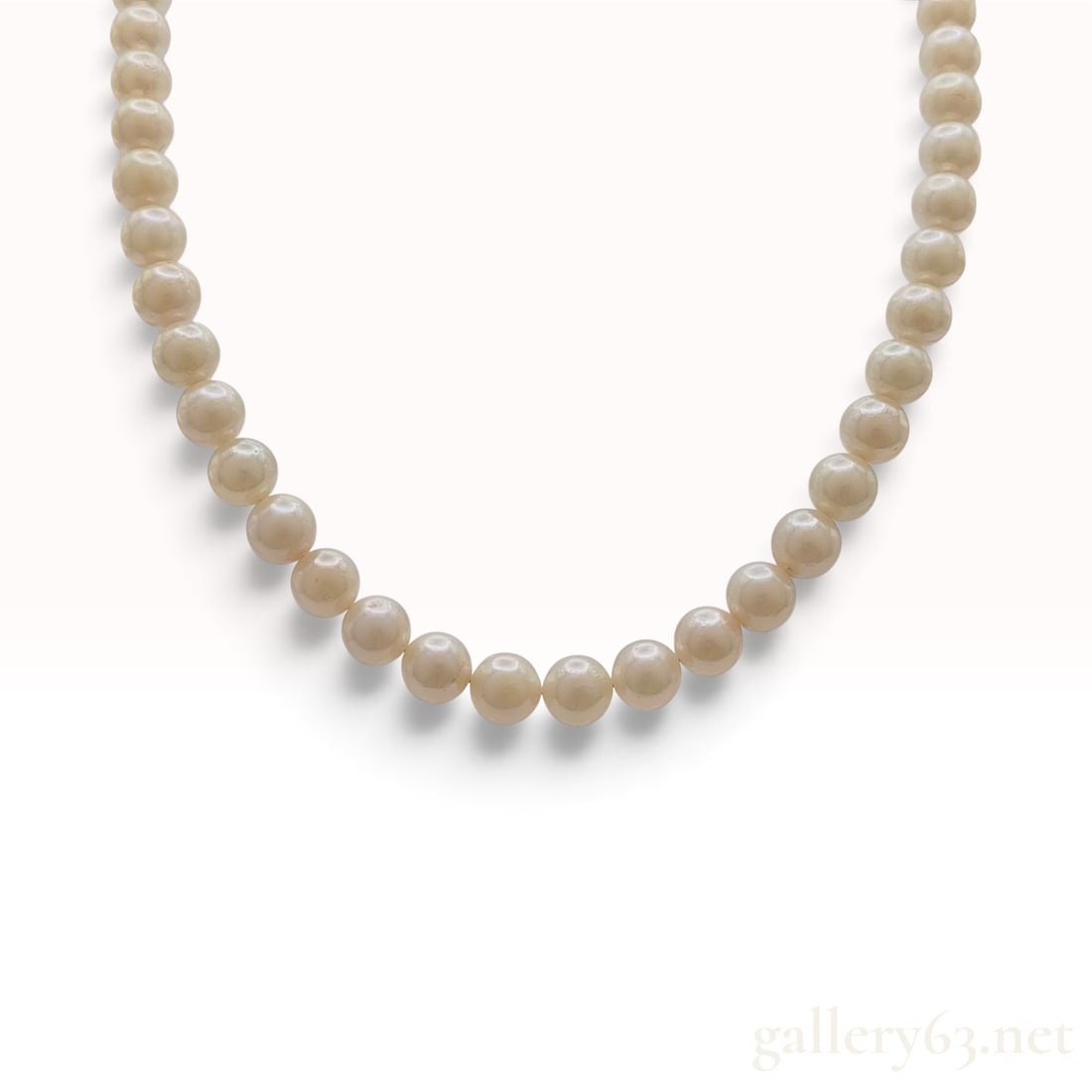 Vintage Silver and 6mm to 6.5mm Cultured Pearl Necklace: This silver necklace is crafted from a single strand of approximately 55 hand-knotted cultured pearls on white silk thread. The pearls are near-uniform in shape, ranging from round to near-round, and 