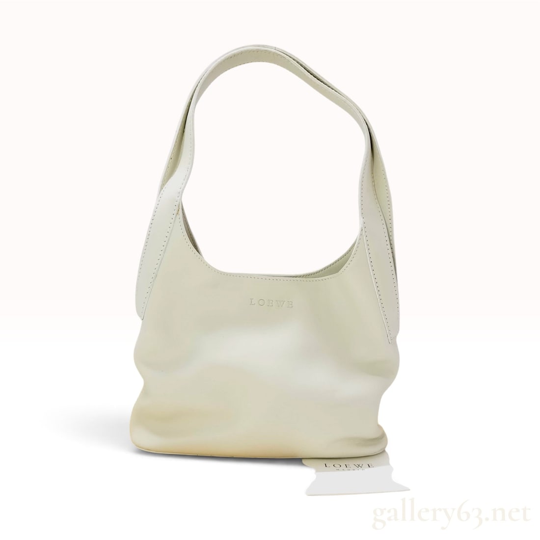 Loewe Cream Leather Hobo Shoulder Bag with Retail Tag: This Loewe hobo shoulder bag is crafted from cream calfskin leather, featuring a minimalist slouchy silhouette with an integrated flat shoulder strap. The interior is lined in tonal cream suede and le
