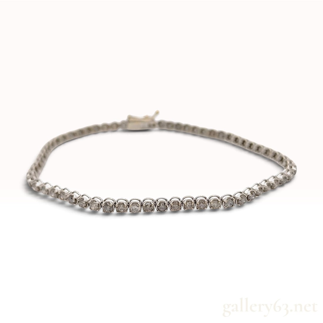 A 3.00ctw Natural Diamond 18KWG Tennis Bracelet: This tennis bracelet features a continuous line of individually set round brilliant-cut natural diamonds totaling 3.00ctw. The diamonds exhibit varying degrees of clarity with visible dark carbon incl