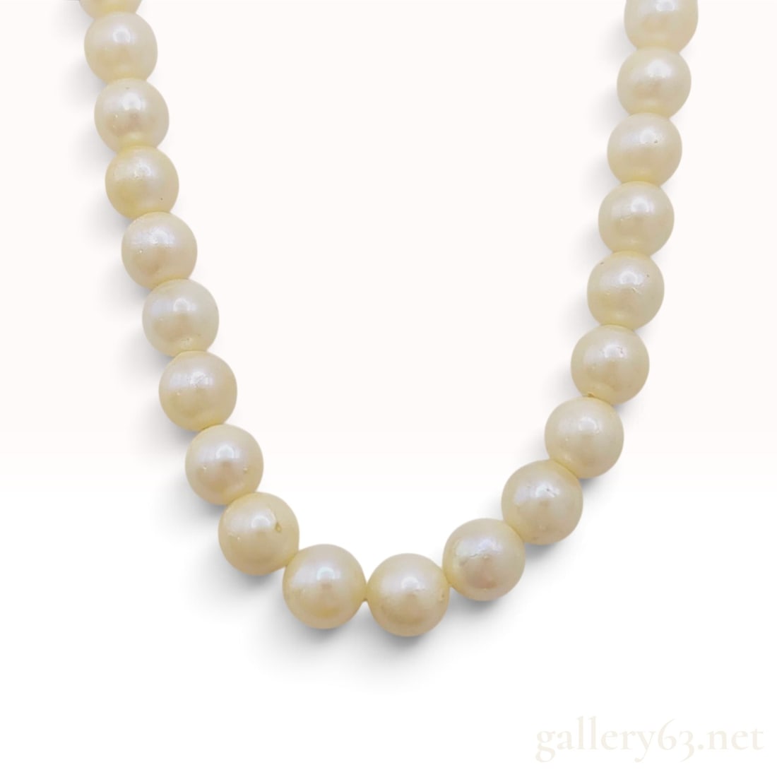 Vintage Sterling Silver and Cream Cultured Pearl Necklace: This vintage single-strand cultured pearl necklace is composed of approximately 49 cream-colored pearls with a medium luster. The pearls display natural surface characteristics including minor pitting