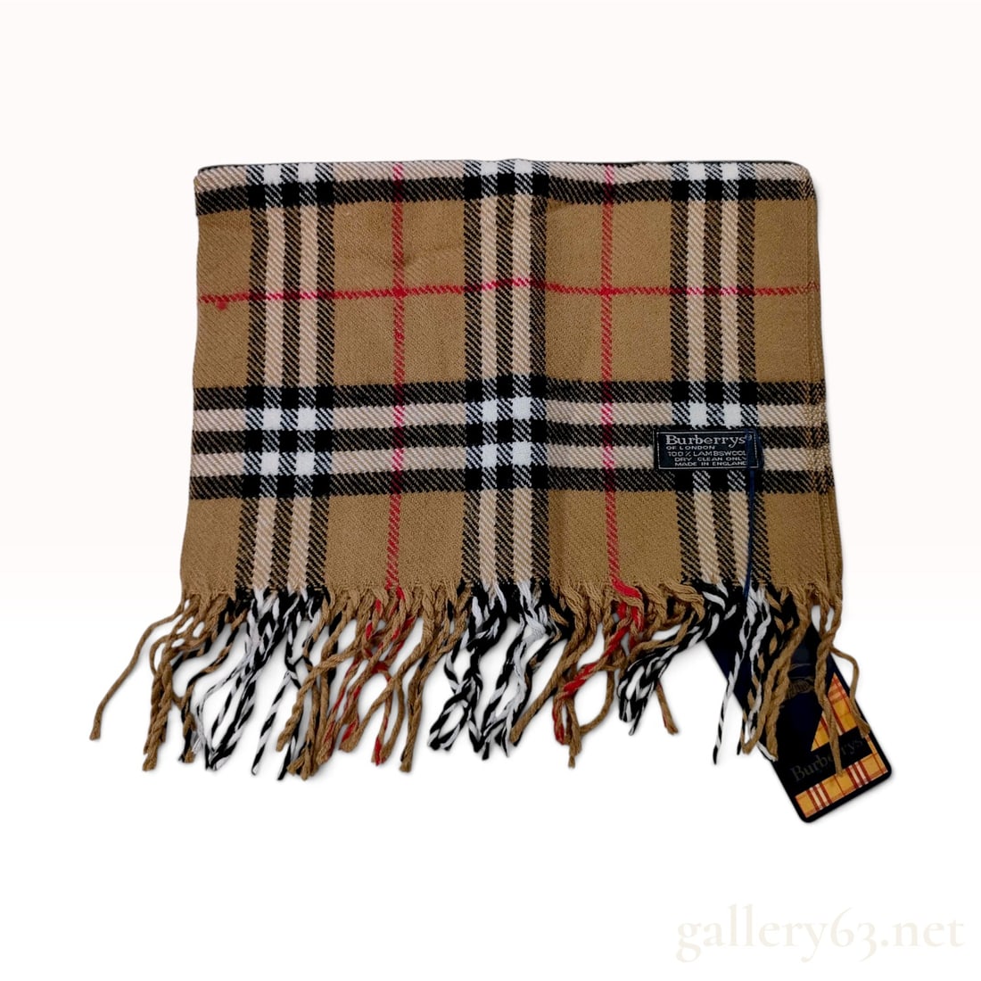Vintage Burberrys Nova Check Lambswool Scarf NWT: This Burberrys scarf is crafted from 100% lambswool in the signature Nova Check pattern. The design features a camel-colored ground intersected by a grid of black, white, and red stripes. The scarf is