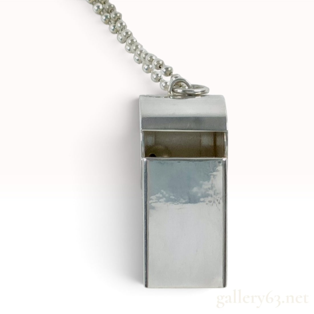 Tiffany & Co. Sterling Silver Whistle Pendant Necklace: This is a Tiffany & Co. whistle pendant necklace crafted from sterling silver. The pendant is modeled after a traditional athletic whistle, featuring a cylindrical chamber and a flat, rectangular mout