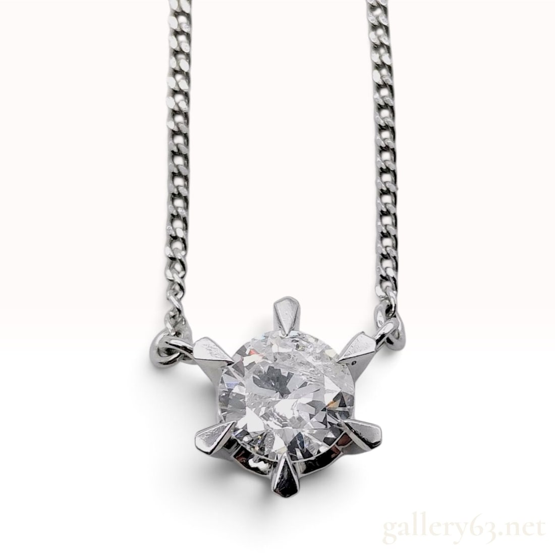 Pt850 Platinum and 0.59ct Natural Diamond Solitaire Pendant Necklace: This Pt850 platinum solitaire pendant necklace features a 0.59ct round brilliant-cut natural diamond. The gemstone is held in a decorative six-prong mounting characterized by a star-shaped profile. Th