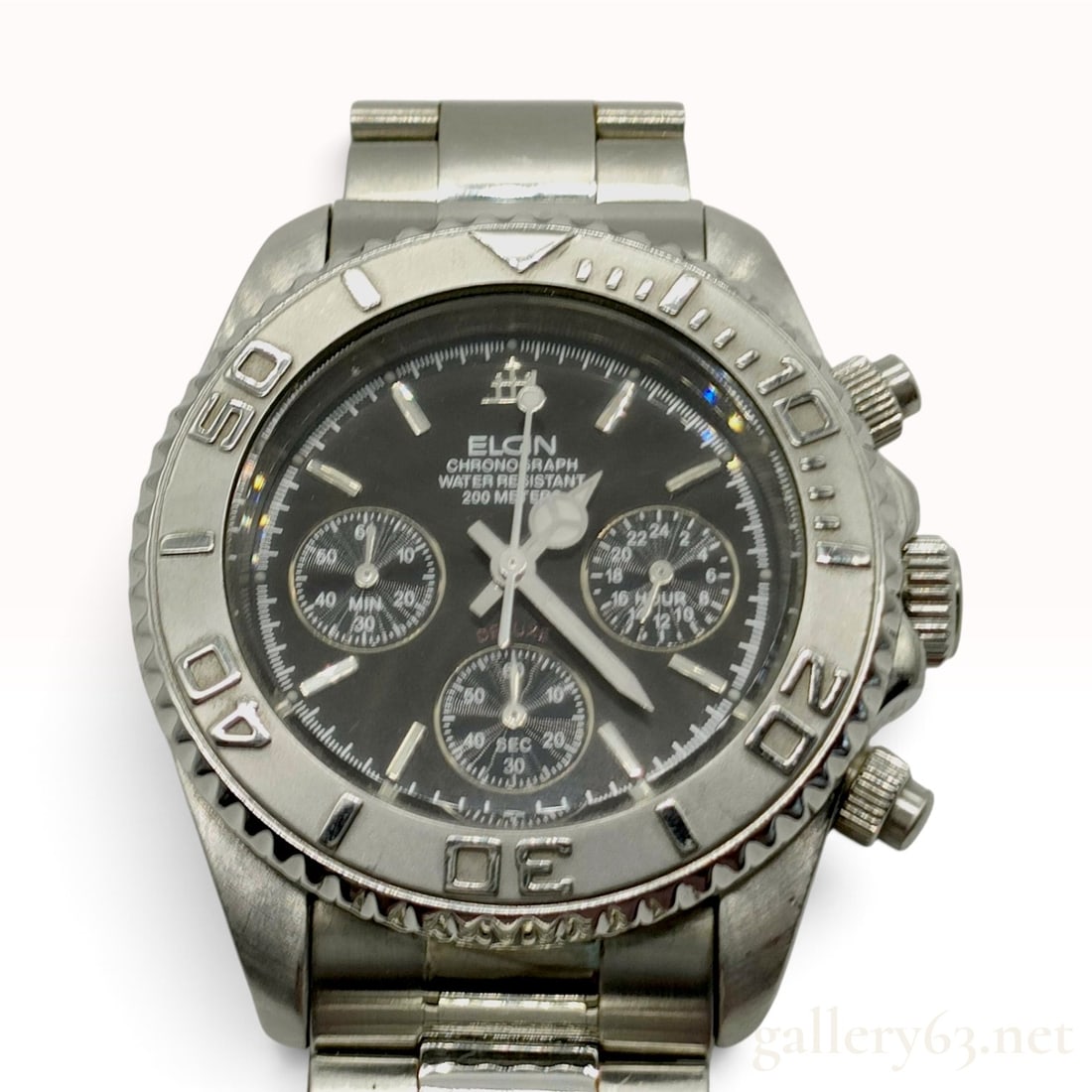 Elgin Chronograph Treasure FK-1120-E Stainless Steel Wristwatch: This Elgin chronograph wristwatch features a stainless steel case and integrated link bracelet. The black dial is set with luminous dot and baton hour markers and luminous hands. Three sub-dials displ